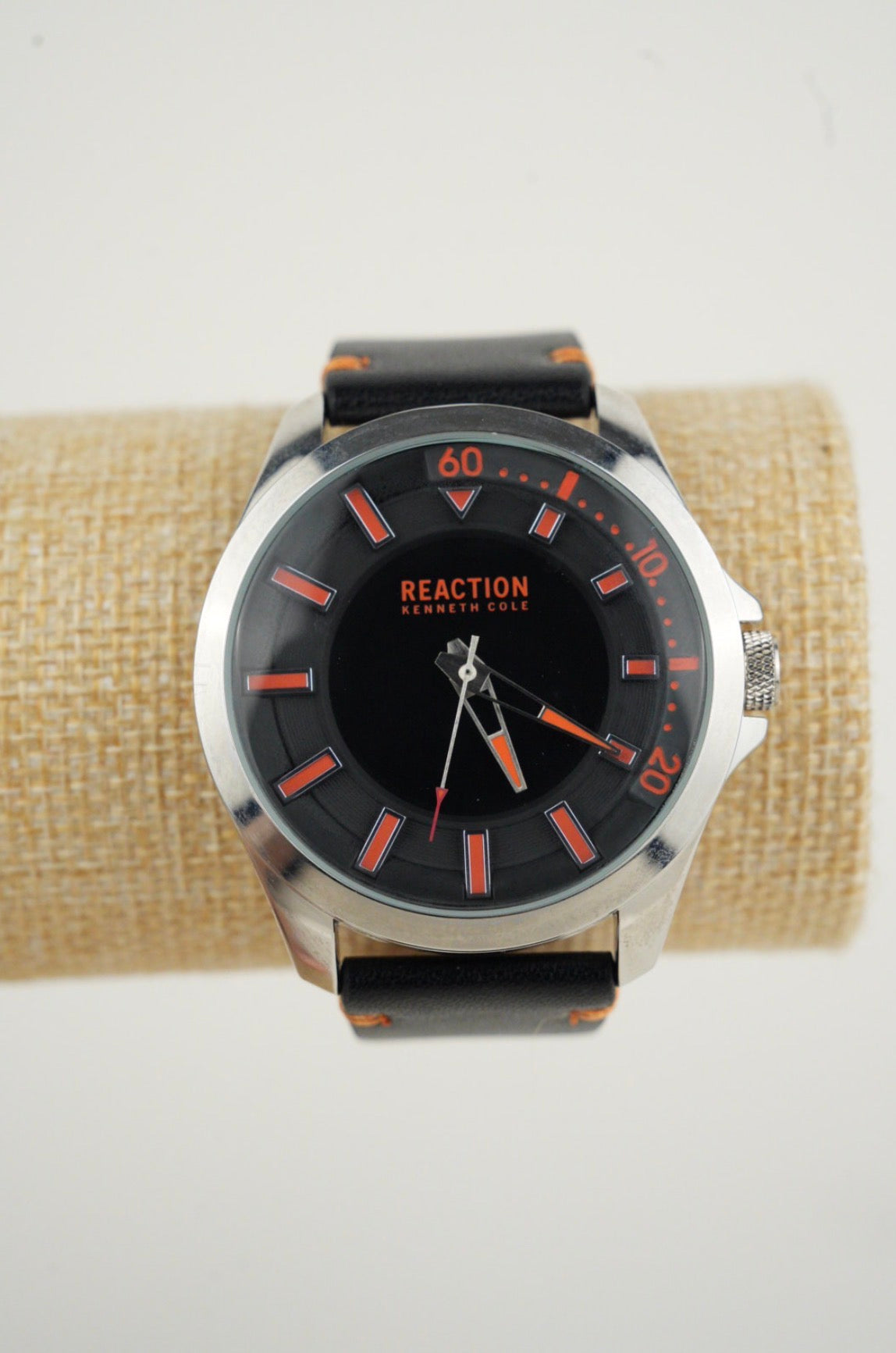 Kenneth Cole Reaction men's analog black leather strap watch with a black dial and orange accents