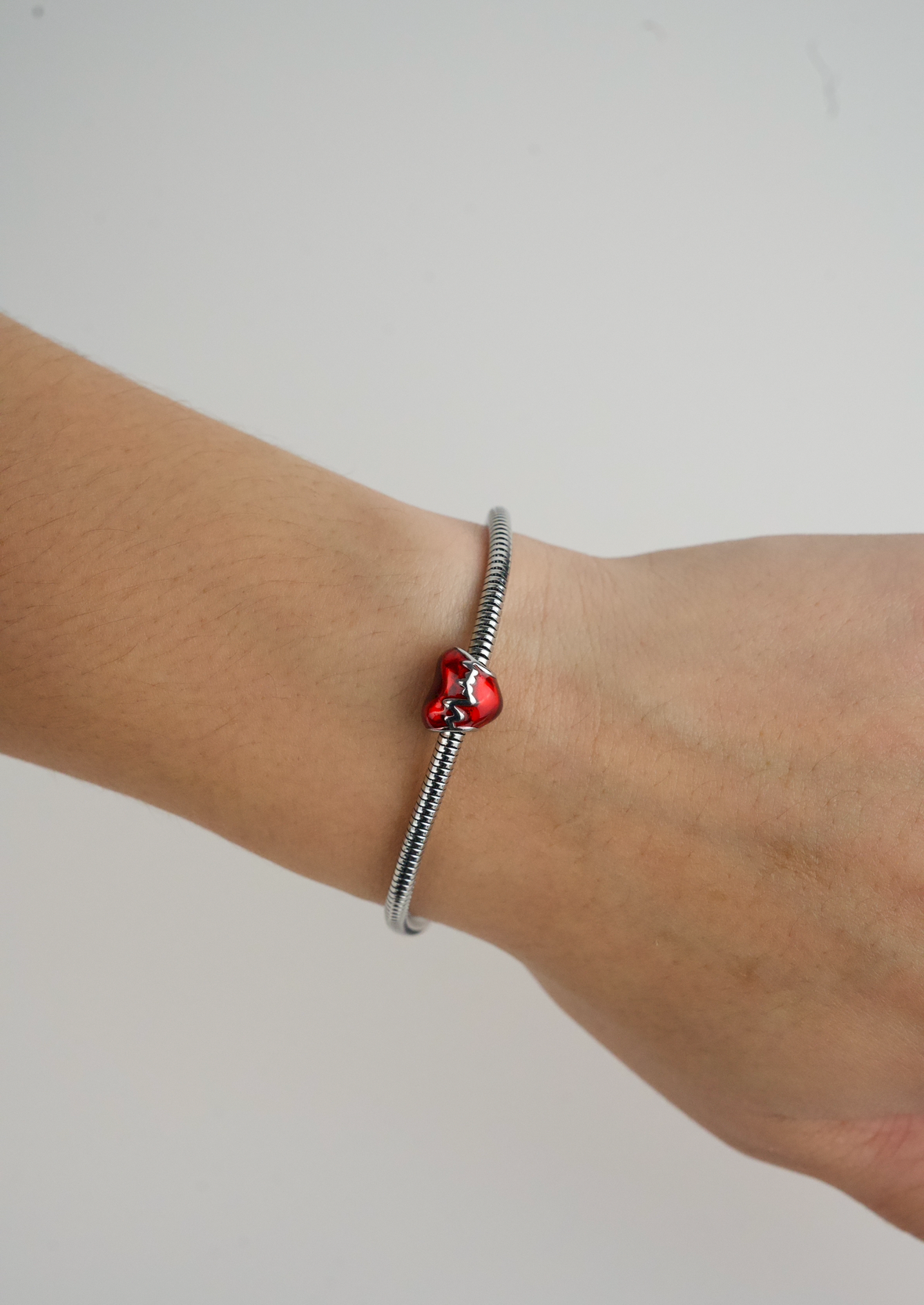 Metallic Red Heart Charm in stainless steel with hand-applied transparent red enamel.