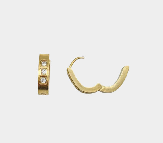 Stainless steel gold huggie hoop earrings with three channel-set diamonds or cubic zirconia in each hoop.