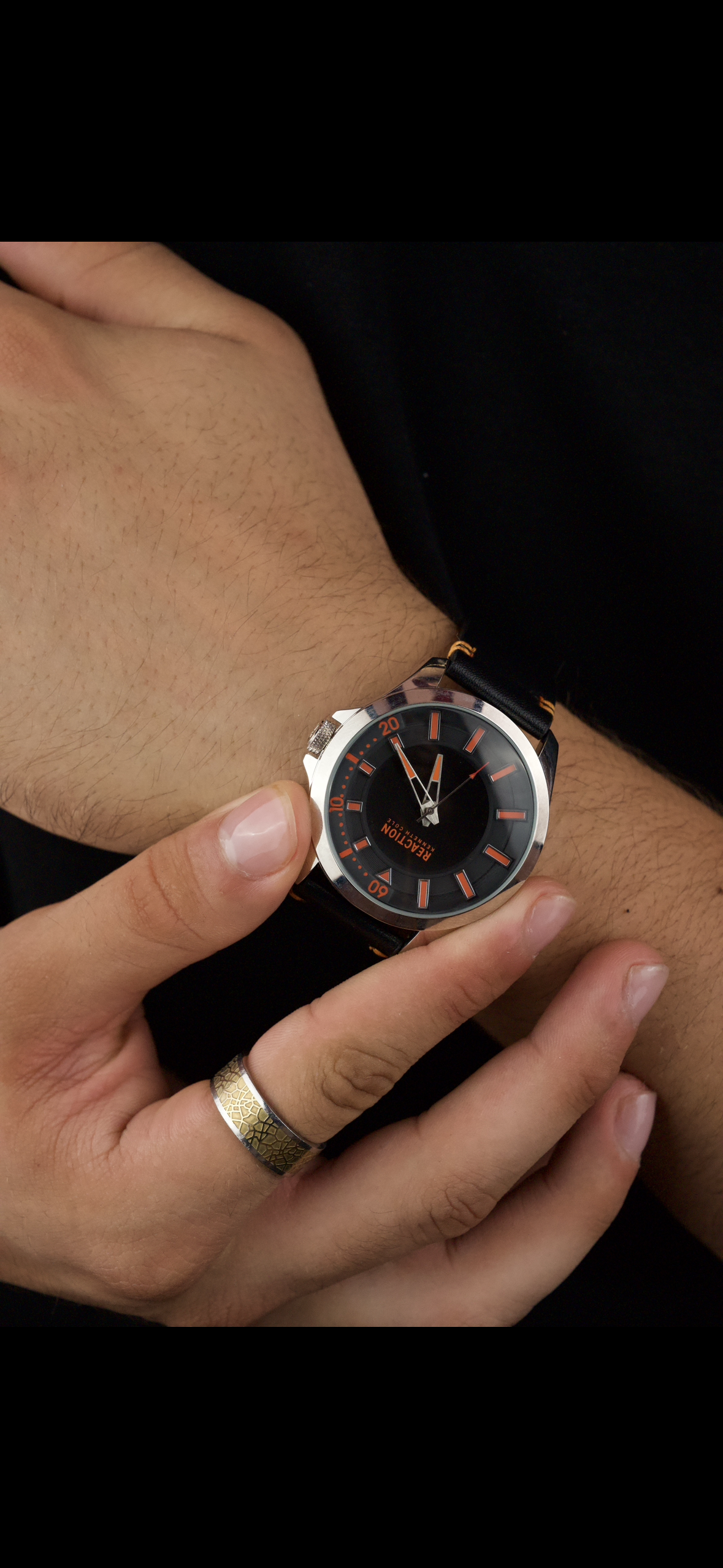 Kenneth Cole Reaction men's analog black leather strap watch with a black dial and orange accents