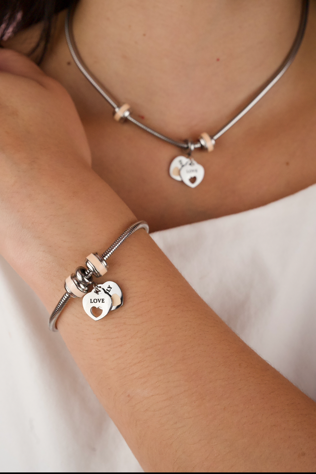 stainless steel snake chain charm bracelet with a heart clasp and a matching necklace.